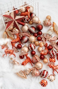 Décorations de Noël rouges et dorées sortant d'un panier sur de la neige artificielle
