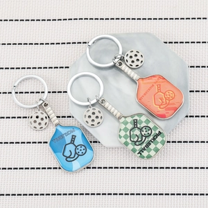 Three colorful pickleball racket keychains in blue, green, and orange with small ball charms