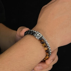 Close-up of men's double-layer bracelet with tiger eye beads and silver cross charm