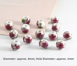 Macro shot of 8mm white ceramic beads with purple floral pattern and 3mm hole for DIY