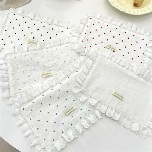 Detail of heart pattern fabric placemats with white lace edges in various colors
