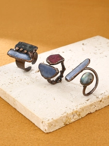 Close-up of vintage bronze open rings with raw kyanite, ruby and labradorite stones