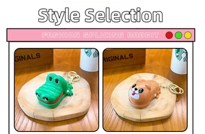 Detail of green crocodile and brown bear cartoon keychains with shiny finish and gold rings