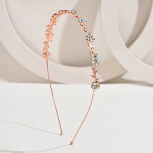 Detail of rose gold flower headband with iridescent crystals and metallic leaves
