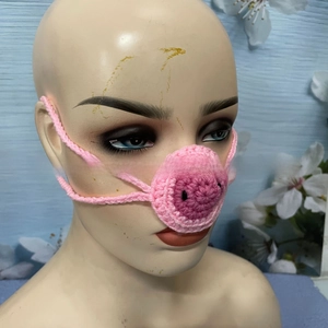 Detail of pink hand-knitted pig nose warmer with comfortable crochet elastic ear loops