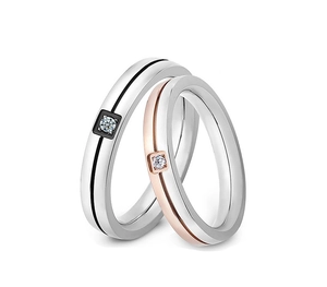 Detailed close-up of two-tone stainless steel couple rings with central square-cut diamonds