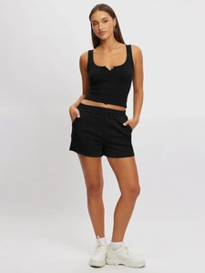 Detailed close-up showing the ribbed texture of the black slim-fit tank top and drawstring shorts