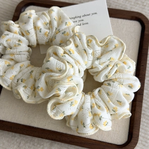 Floral scrunchies set in creamy white with yellow flowers on a rustic wooden tray