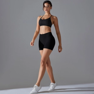 Detail of seamless black sports bra and high-waist shorts set with elastic texture