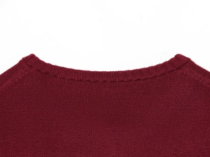 Détail d'un pull en maille bordeaux montrant l'encolure côtelée et la couture précise