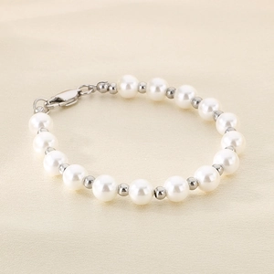 Detail of round white pearls and silver metal beads with lobster clasp on silk