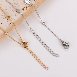 Close-up of gold and silver Christmas tree anklets with small diamonds and extension chains