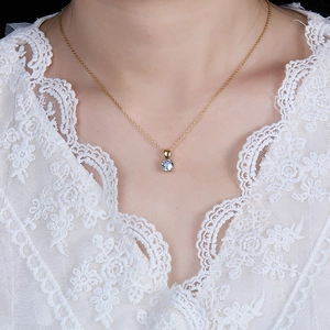 Close-up of a 925 sterling silver birthstone necklace featuring a blue zircon on a gold chain