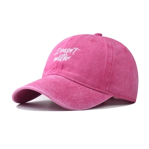 Détail de la casquette rose en coton délavé avec broderie blanche sur le devant