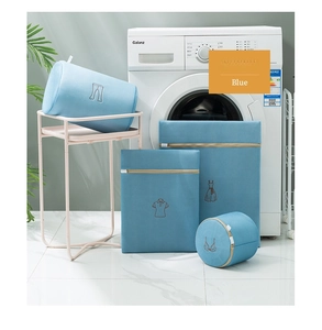 Detailed Morandi blue mesh laundry bags with embroidery icons next to washing machine