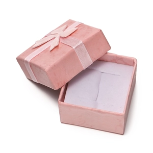 Detailed view of an open pink jewelry gift box with ribbon bow and white sponge insert