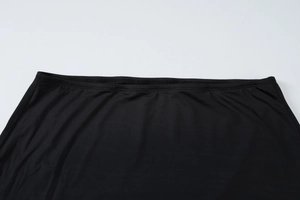 Close-up of the elastic waistband and stitching detail on the black bodycon skirt