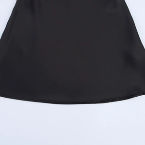 Detailed close-up of the smooth hemline and stitched edge on a black satin mini dress