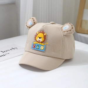 Close-up of beige baby baseball cap featuring 3D ears and cartoon lion patch