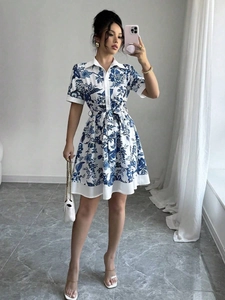 Detail of blue and white floral shirt dress with waist tie and button-up front