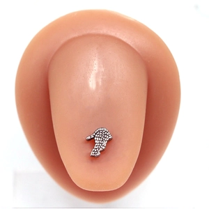 Silver skull textured tongue ring on silicone model for professional body piercing display