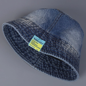 Detailed view of washed denim bucket hat with orange contrast stitching and label