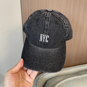 Detailed view of NYC white embroidery on a washed vintage denim baseball cap