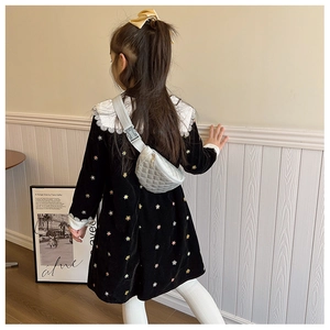 Detail of child wearing a silver quilted crossbody bag over a black velvet dress