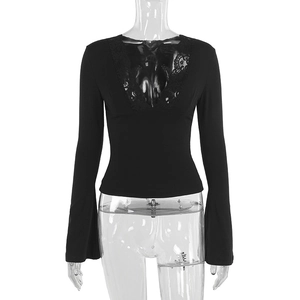 Detailed close-up of the lace V-neckline and bell sleeve design on the black top