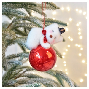 Detail of a plush white bear with red sequin bowtie on a festive red ornament ball