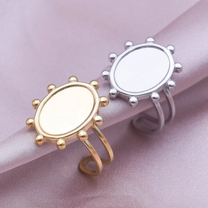 Detailed macro view of gold and silver oval geometric rings on elegant purple satin silk