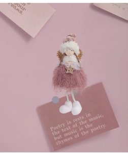 Pink plush angel doll with golden wings and star detail on soft decorative background