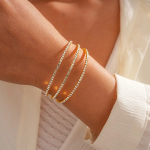 Detail of three-layer 18K gold plated tennis bracelets with sparkling zircon on wrist
