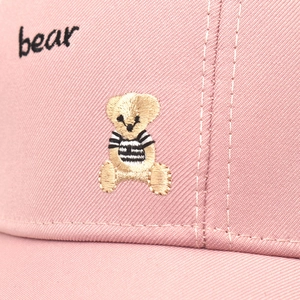 Macro d'une casquette rose en coton avec broderie ours et texte bear détaillé