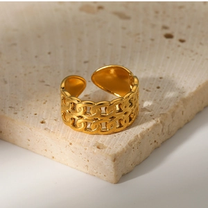 Detailed view of the double-layer golden chain-link open ring on a textured stone base