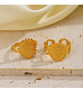 Close-up of 18K gold plated octagram rings on marble and cream silk background