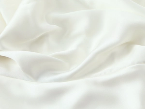 Macro view of pearl white satin fabric showing silky texture and soft draping