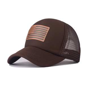 Detail view of brown trucker hat with American flag leather patch and mesh back