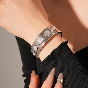 Détail d'un bracelet en résine plaqué or avec surface polie et incrustation de pierre