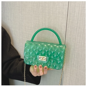 Detail of green jelly purse showing quilted texture, beaded handle, and gold chain strap