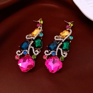 Detailed macro view of gold earrings with multicolor gemstones and white crystal accents