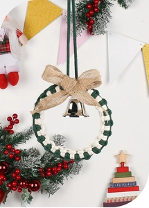 Detail of Macrame Christmas wreath with a burlap bow and silver metal bell chime