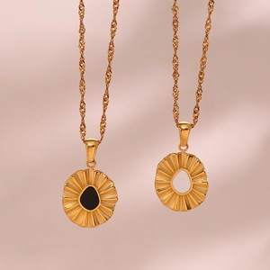 Detailed macro view of gold water wave chains with black and white sunburst pendants