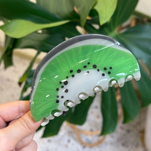Handheld acrylic kiwi fruit hair claw clip featuring fresh green and white details