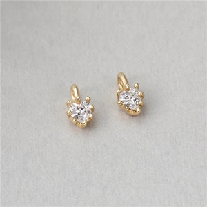 Detailed close-up of golden heart pendants with sparkling white zircon inlays