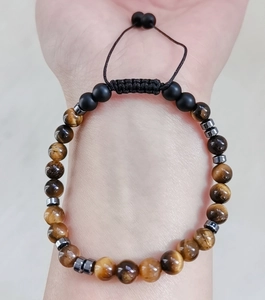 Nahaufnahme eines handgefertigten verstellbaren Tigerauge-Stein-Armbandes am Handgelenk getragen