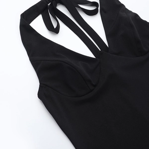 Macro shot of V-neckline detail and halter strap on a sleek black bodycon dress