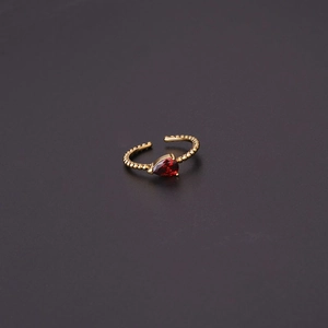 Macro shot of gold beaded ring featuring a red pear-cut zircon and adjustable band