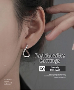 Détail de boucles d'oreilles minimalistes en forme de U torsadé argenté sur le mannequin