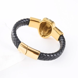 Men's black braided leather bracelet with golden skull charm and magnetic clasp
